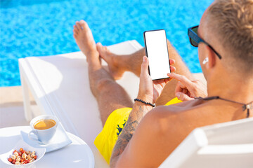 Man using cellphone by the pool, white screen mockup