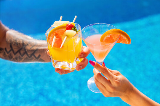 Couple holding cocktail classes by the pool