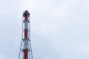Obraz premium Metal industrial chimney. A large chimney of a boiler room against a gray sky.