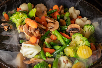 Pan with frozen vegetable mix for frying.