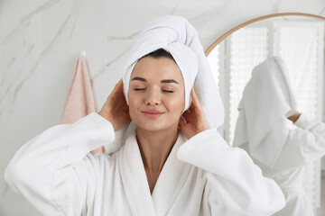Beautiful young woman with hair wrapped in towel indoors