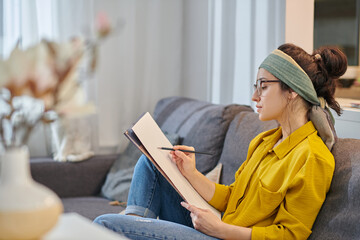 Young painter sitting in the studio with an inspired look