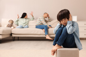 Couple arguing at home, focus on their upset child