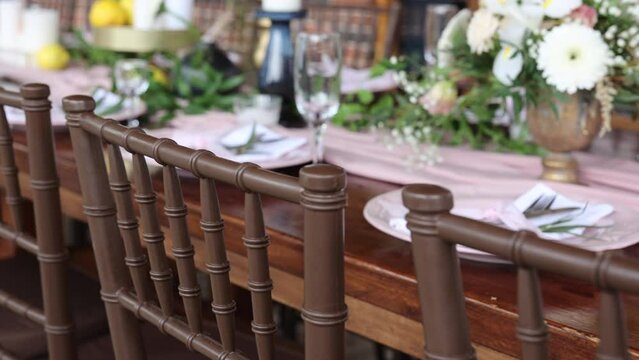 Wooden chairs at the table. Brown chiavari chairs. Luxury jewelry for the wedding day.