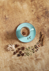 Masala tea spiced tea with milk and spices on wooden background, top view , copy space