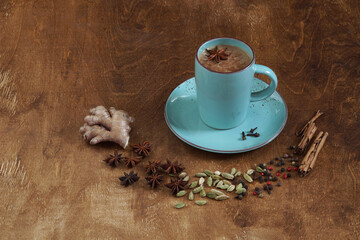 Traditional Indian drink - masala tea with spices. Cinnamon, cardamom, anise, pepper on a dark wooden background. Copy space. Side view
