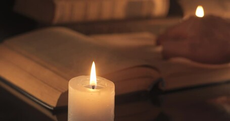 A man reads and turns over the yellow pages of an old book