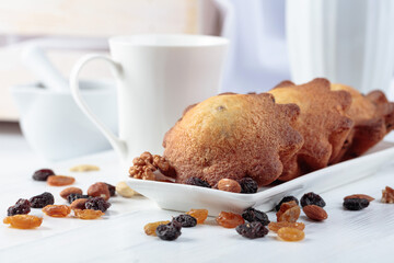 Cupcakes with nuts and raisins on a kitchen table.