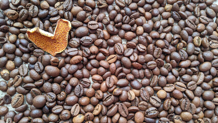 Orange peel hearts on coffee beans background