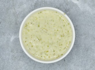 Raita with mint, herbs and onion in a bowl top view on dark grey background indian pakistani food