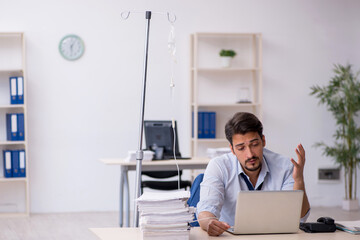 Young male employee suffering at workplace