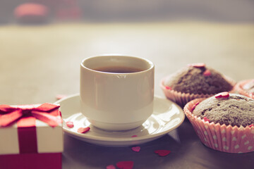 Cup of coffee, chocolate muffins and gift.