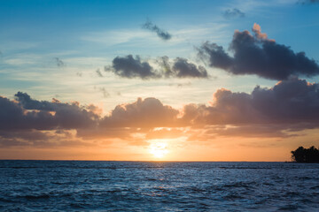 Fototapeta premium Beautiful sunrise at sea. Dawn on the Atlantic ocean. The sun is reflected in the sea. Palm trees against the background of the rising sun. Tropical sunrise. Dominican Republic