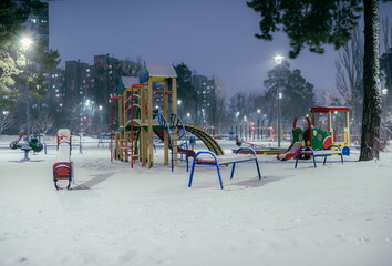 Fototapeta na wymiar The playground in the night park with lanterns in the winter. Be