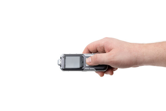 The voice recorder is isolated on a white background. Dictaphone in hand close-up on a white background. - Powered by Adobe