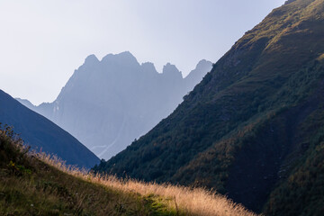 A panoramic view on the sharp mountain peaks of the Chaukhi massif in the Greater Caucasus Mountain Range in Georgia, Kazbegi Region. Mountain Ridges, Hiking. Georgian Dolomites.
