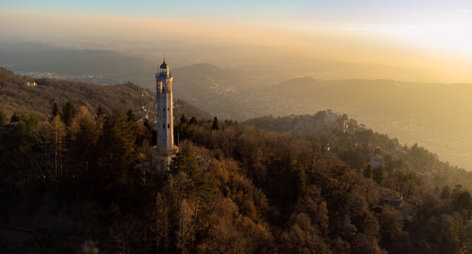 Aerial drone view of a lighthouse in the middle of the mountains with sunset light