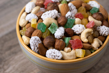 Sweets, raisin, candied fruit and nuts in a bowl on a table.
