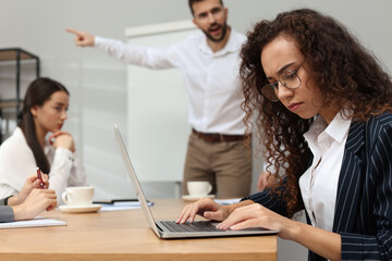Man screaming at African American woman in office. Racism concept