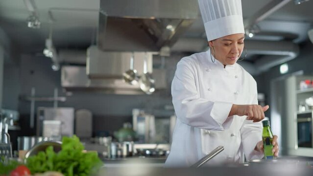 Restaurant Kitchen Cooking: Portrait of Black Female Chef Ads Oil, Holds Frying Pan, Stirs Her Favourite Flavourful Dish, Smiles. Professional Cook Delicious, Traditional Authentic Food, Healthy Dish