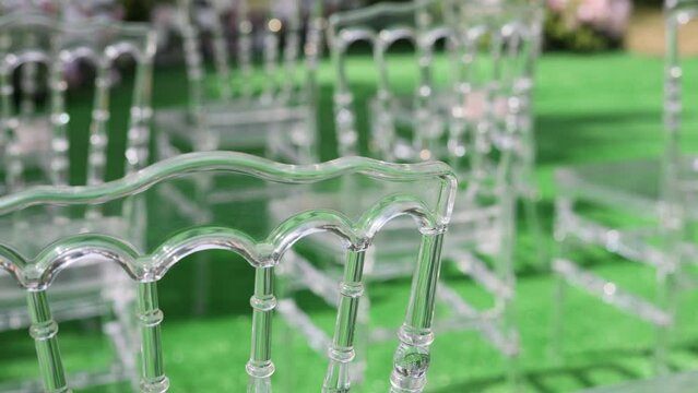 Chiavari transparent chairs in the ceremony area. Luxury decorations for a wedding day on a sunny summer day.