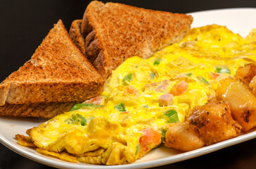 Omelet with a side of breakfast potatoes and toast.