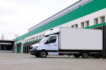 Truck near loading dock of warehouse outdoors. Logistics center