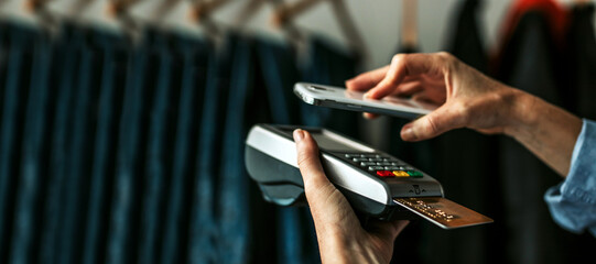 hand paying with mobile phone in store
