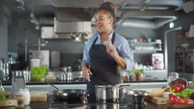TV Cooking Show in Restaurant Kitchen: Portrait of Black Female Chef Talks, Teaches How to Cook Food. Online Courses, Streaming Service, Learning Video Lectures. Healthy Dish Recipe Preparation