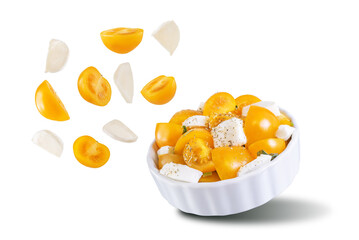 Yellow tomatoes basil pepper mozarella salad in a bowl on a white isolated background