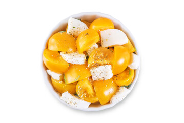 Yellow tomatoes basil pepper mozarella salad in a bowl on a white isolated background