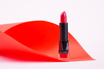 Single opened tube of satin finish red lipstick, studio shot