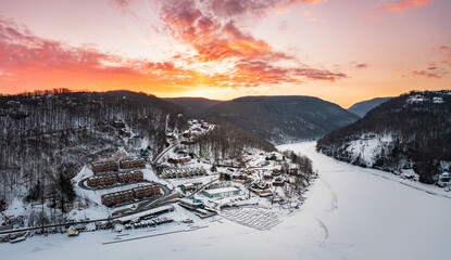 Aerial drone panorama of spectacular sunrise over the frozen and snow-covered Cheat Lake looking upriver into the gorge near Morgantown, West Virginia