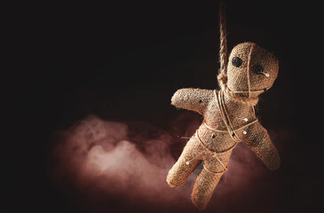 Voodoo doll with pins and smoke on dark background. Space for text