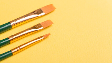 Paint brushes isolated on  yellow background. For art