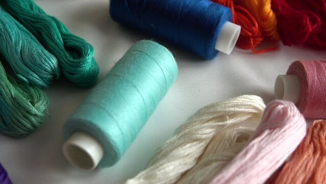 A top view of colorful mouline threads and multicolored spools isolated on a white background.