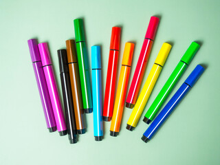 A set of multicolor felt-tip pens, multi-colored felt-tip pens on a green background with space for text