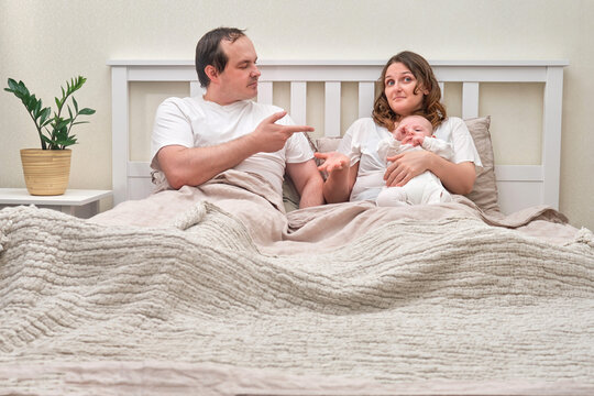 Ascertaining the paternity of a child between mother and father. Man and woman and with newborn baby in the bedroom