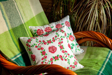 Two pillows with embroidery in the shape of roses.