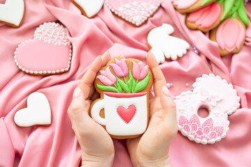 background banner greeting card for international women day with cup in woman hands, tulips and pigeon shape gingerbread cookies on silk fabric background