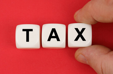 On the red surface, white cubes with the inscription - TAX