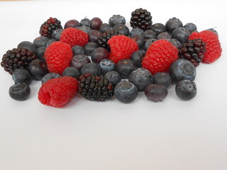 Blaubeeren, Himbeeren und Brombeeren auf weißem Hintergrund mit Platz für Text