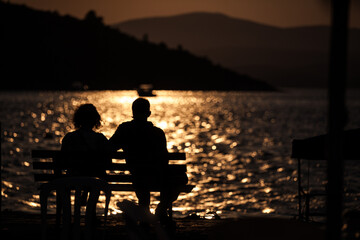 Fototapeta na wymiar Romantic couple watching the sea at sunset