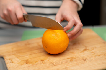 Two cute sister girls are making orange fresh juice.Hands close-up. They are in the kitchen at home. Family. Fresh fruit.