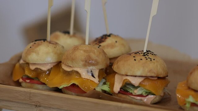 miniburgers on a wooden tray. snacks on the table, catering concept. 