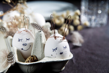 Easter concept. A white egg with copper wire ears and a painted rabbit sleeping face in a box....
