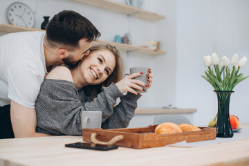 Young couple having breakfast in kitchen.