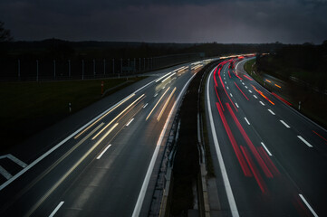 Lights of driving cars on a highway at night in Germany, long exposure with motion blur, copy space
