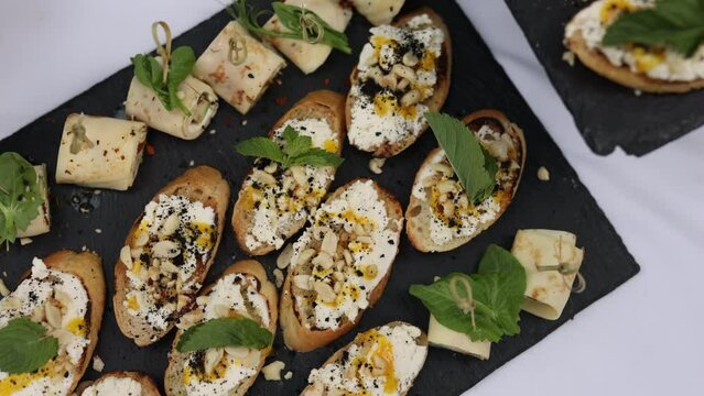 small canapes and French bread sandwiches on a tray. snacks on the table, catering concept. 