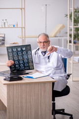 Old male doctor radiologist working in the clinic